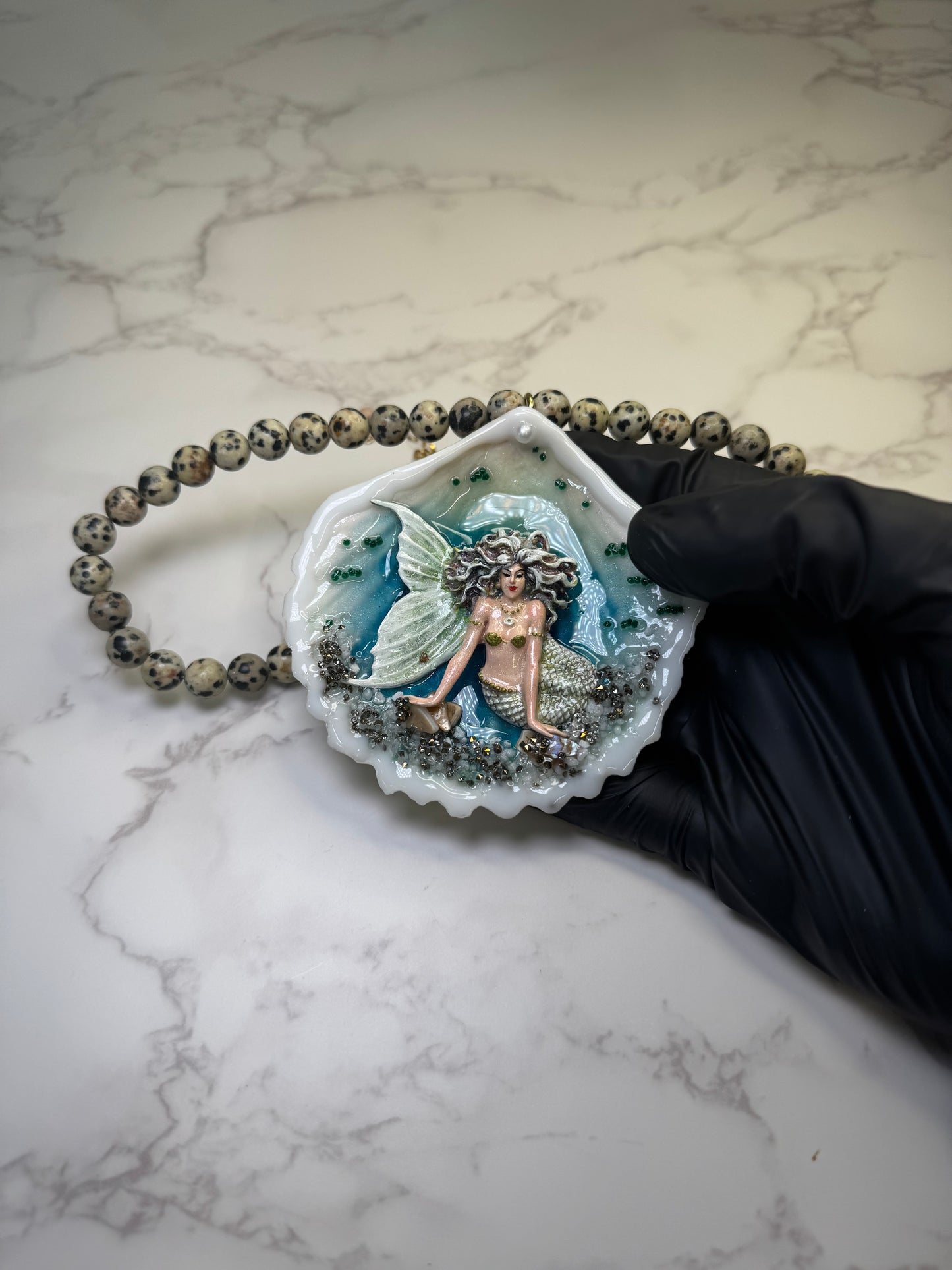 Moonshell Siren Natural seashell featuring a handmade craft metal mermaid with white hair and a pearlescent white tail encapsulated in clear UV resin Beautiful semiprecious stones necklace