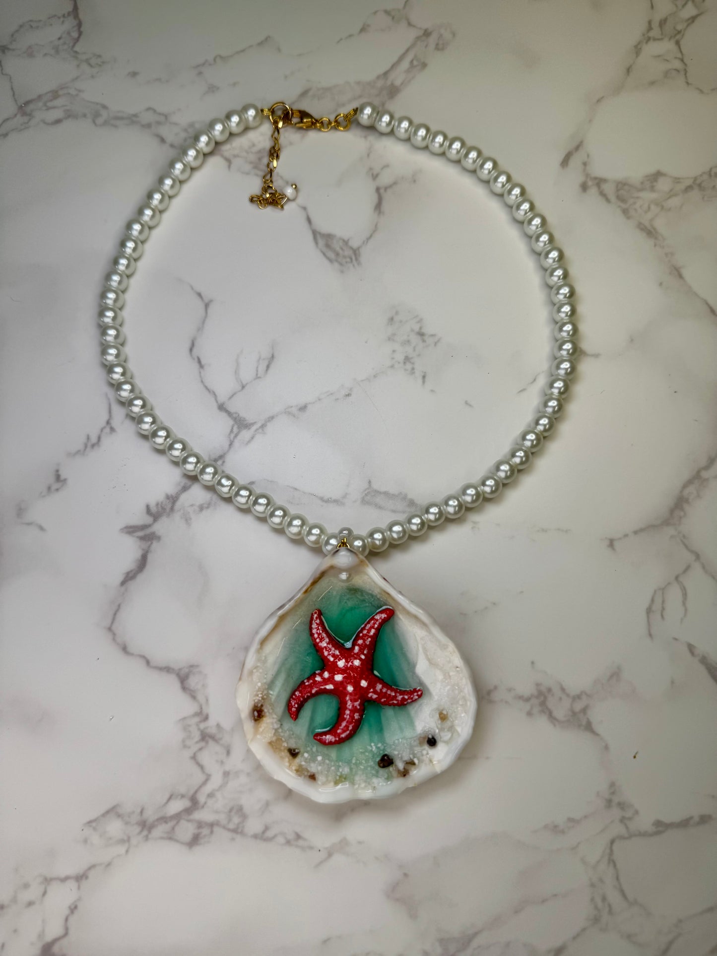 Coral Dawn Natural seashell featuring a red-and-white dotted starfish with sand and miniature coral rocks encapsulated in clear UV resin