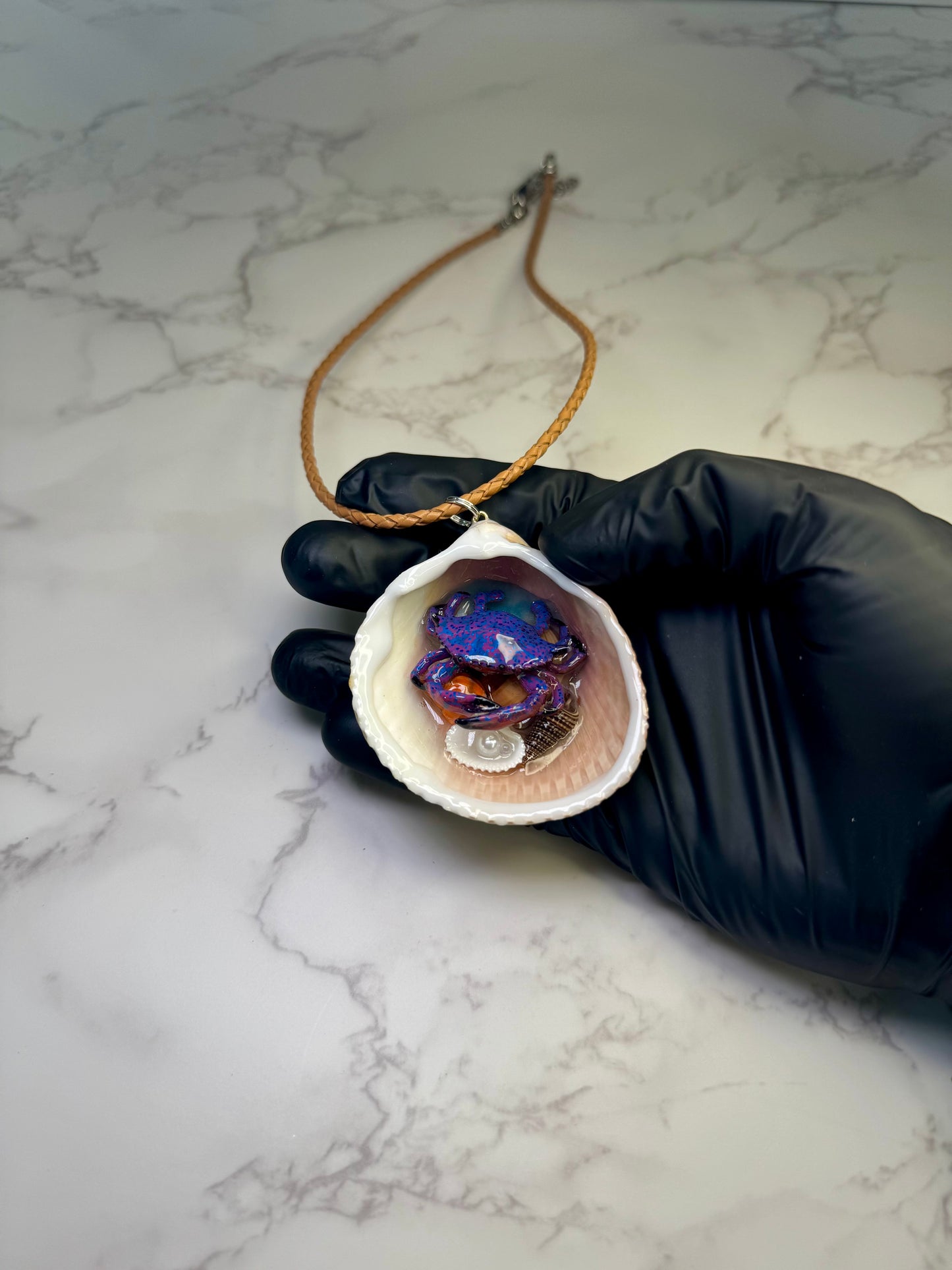 Moonlit Reef Wanderer Natural seashell featuring a handcrafted purple-and-blue spotted crab with tiny seashells encapsulated in clear UV resin Leather Corded necklace