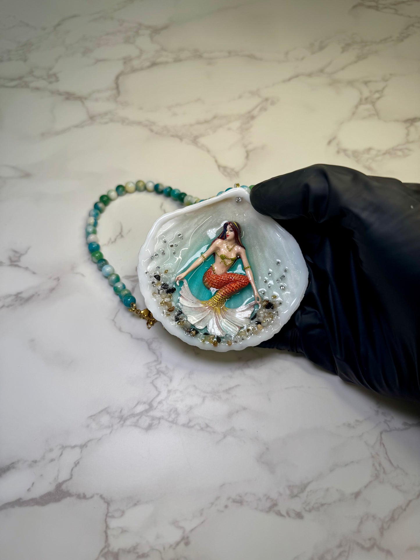 Sunlit Coral Siren Natural seashell featuring a handmade craft metal mermaid with brown hair, yellow highlights, and an orange–yellow tail encapsulated in clear UV resin Beautiful semiprecious stones necklace