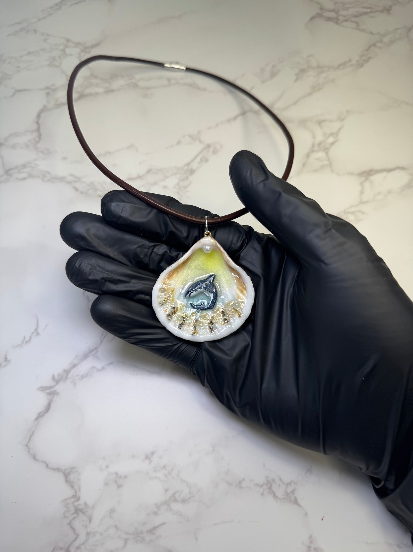 Mini Tide Hunter Tiny natural seashell featuring a handmade craft metal miniature shark and small crystals encapsulated in clear UV resin. Leather necklace