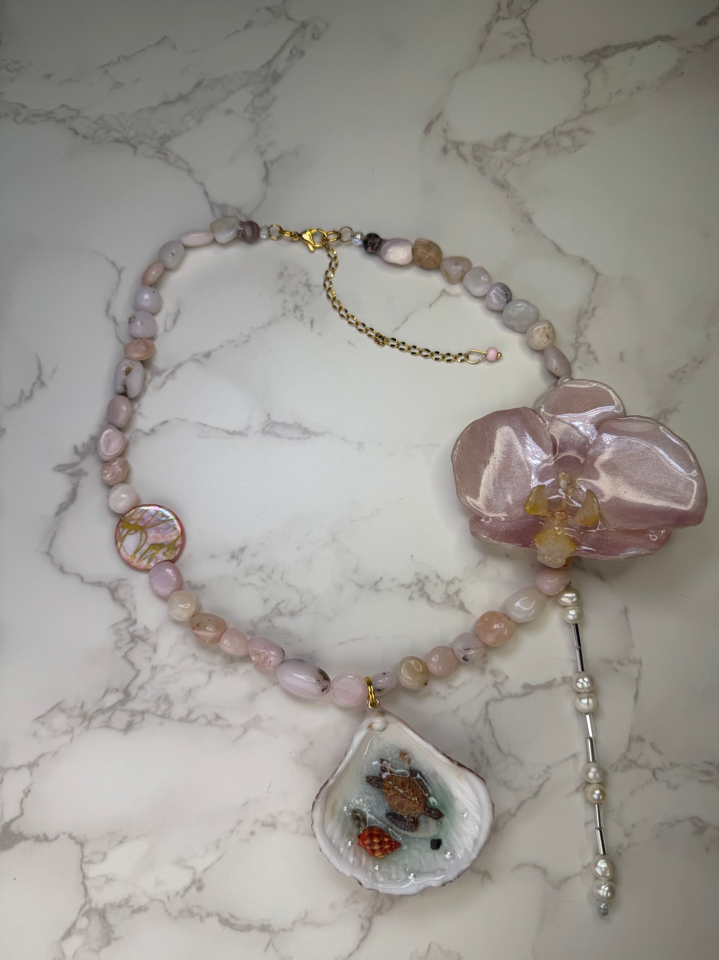 Pink Orchid Blossom Pink orchid flower centerpiece with a pink seashell holding a miniature sea turtle