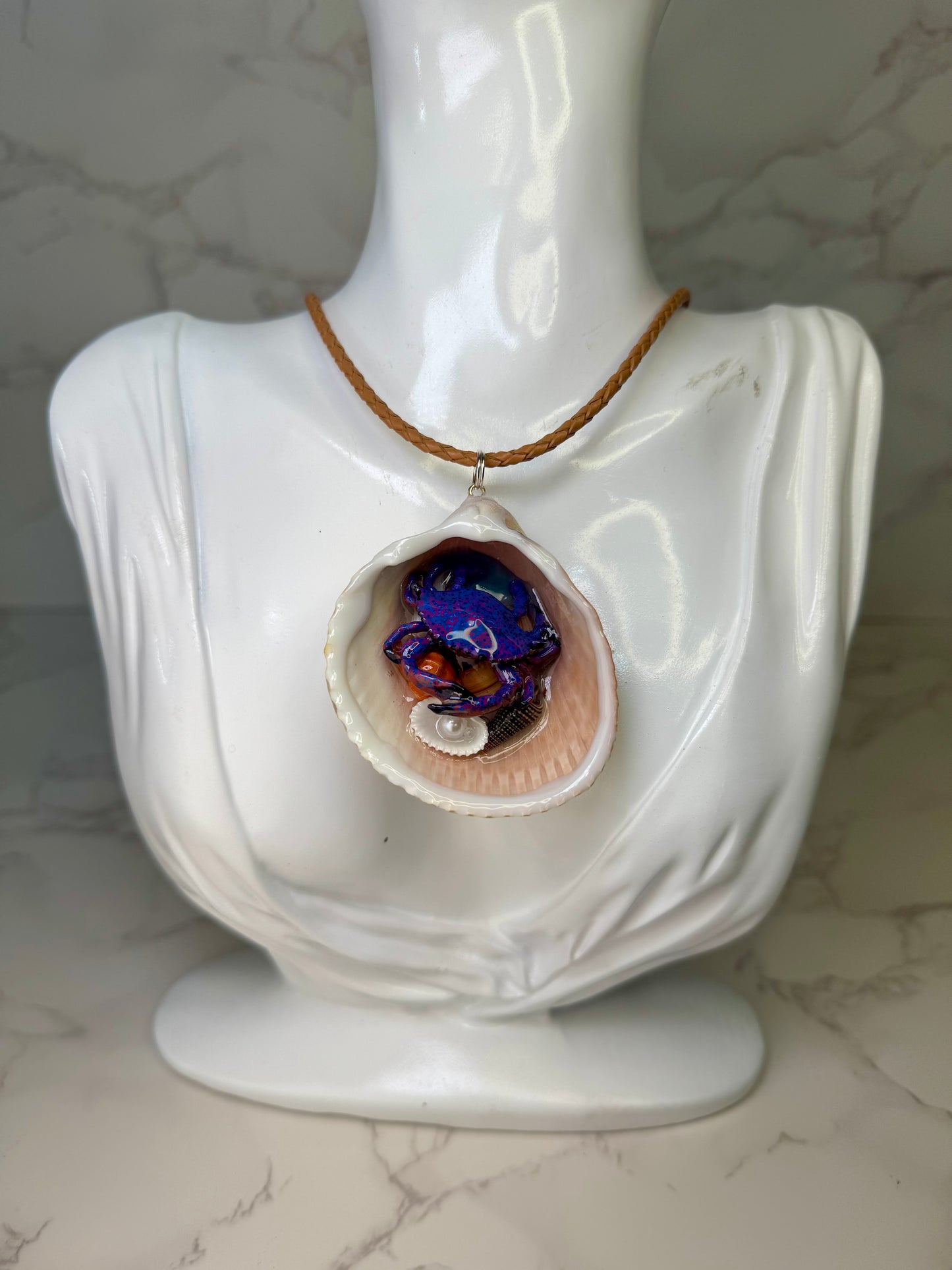 Moonlit Reef Wanderer Natural seashell featuring a handcrafted purple-and-blue spotted crab with tiny seashells encapsulated in clear UV resin Leather Corded necklace