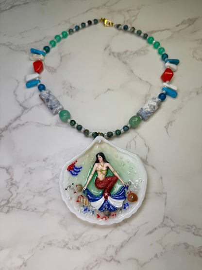 Cuba Libre Mermaid Natural seashell featuring a handmade craft metal mermaid with brown hair and a red tail inspired by the Cuban flag preserved in UV resin Beautiful Stones Necklace Handmade craft jewelry
