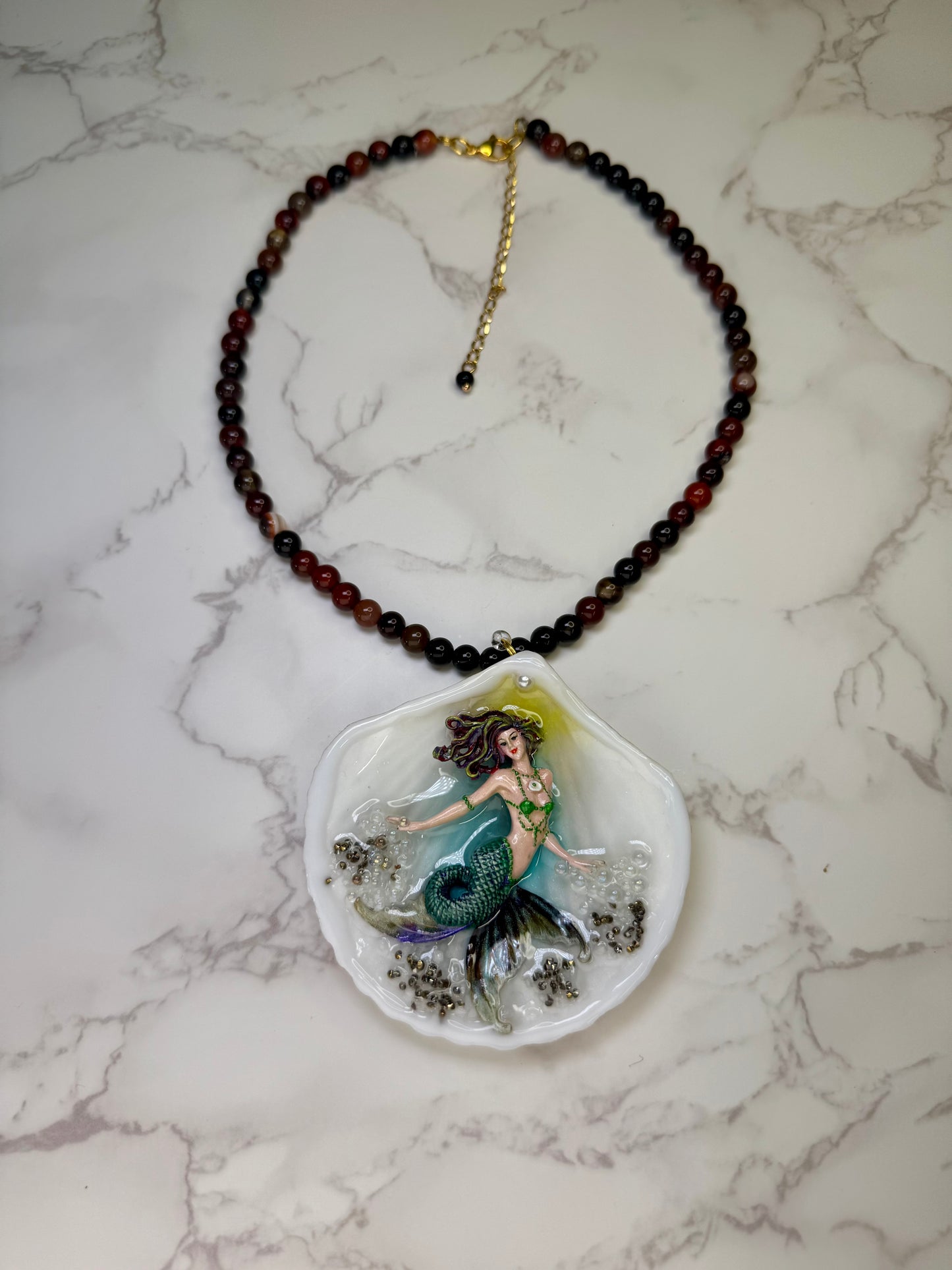 Emerald Dawn Siren  Natural seashell featuring a handmade craft metal mermaid with brown hair, yellow highlights, and a vibrant green tail preserved in Clear Resin Beautiful Stones Necklace