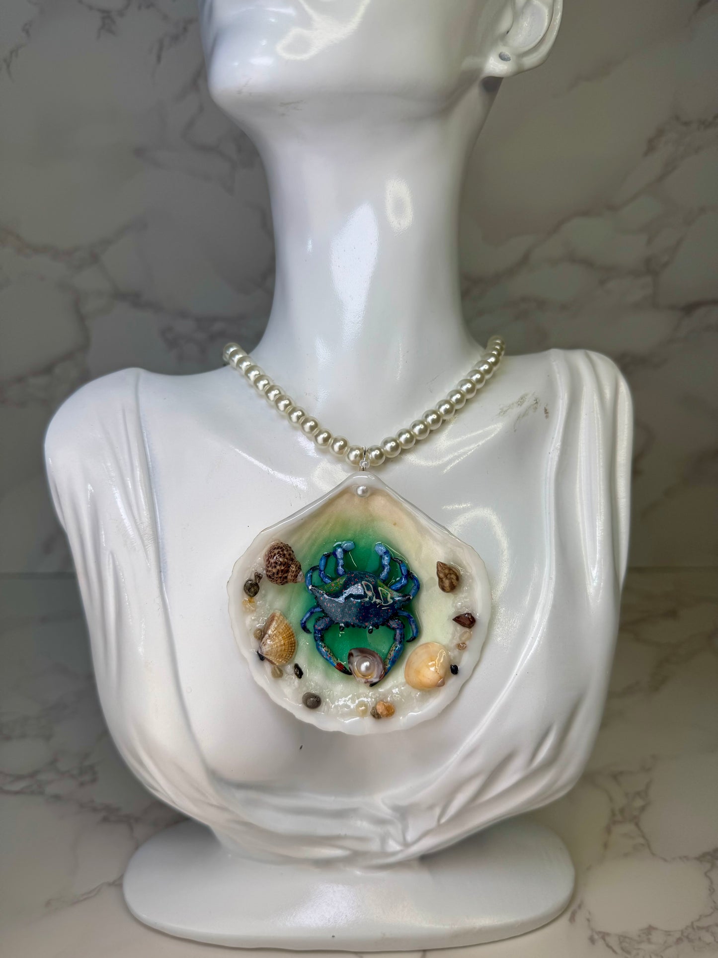 Tidal Blossom Crab Natural seashell featuring a handmade blue-and-pink dotted crab and small seashells encapsulated in clear UV resin Glasses Necklace