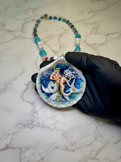 Mooncrest Royal Tides Natural seashell featuring a handmade craft mermaid king holding a mermaid queen, both with white hair and white shimmering tails preserved in UV resin Handmade crafts jewelry Beautiful Stones Necklace