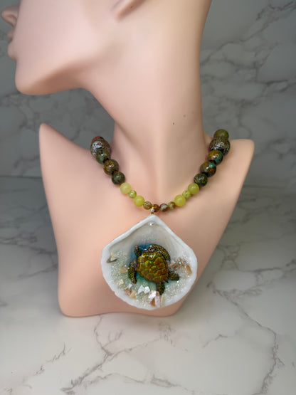 Emerald Tide Guardian Natural seashell featuring a handmade metal green sea turtle, bits of sand, coral, and a green–olive crystal ball necklace encapsulated in clear UV resin Beautiful natural stone’s necklace