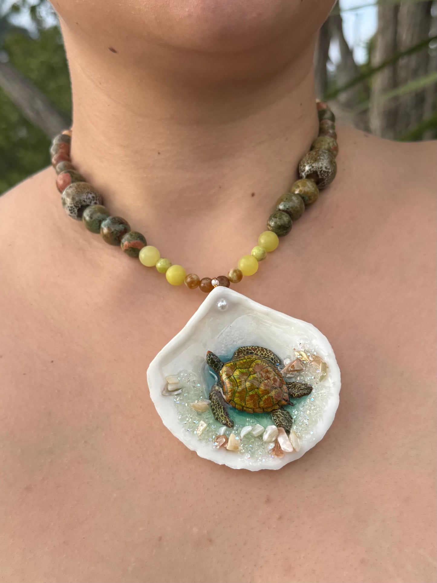 Emerald Tide Guardian Natural seashell featuring a handmade metal green sea turtle, bits of sand, coral, and a green–olive crystal ball necklace encapsulated in clear UV resin Beautiful natural stone’s necklace