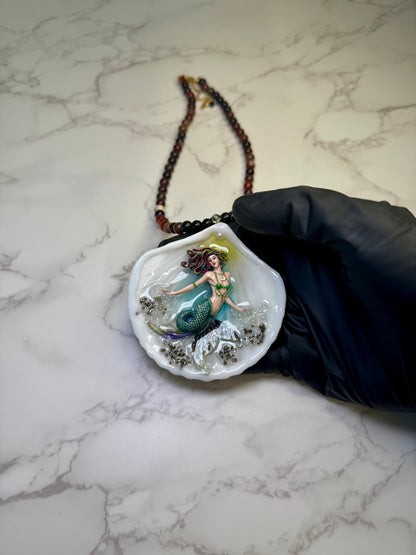 Emerald Dawn Siren  Natural seashell featuring a handmade craft metal mermaid with brown hair, yellow highlights, and a vibrant green tail preserved in Clear Resin Beautiful Stones Necklace