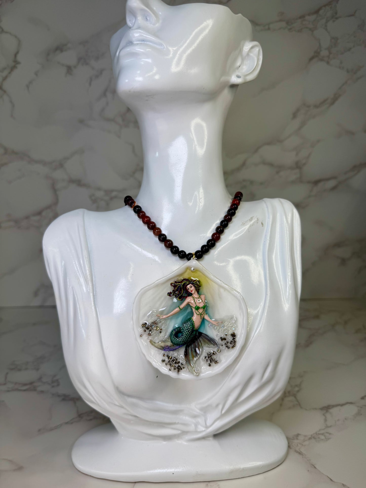 Emerald Dawn Siren  Natural seashell featuring a handmade craft metal mermaid with brown hair, yellow highlights, and a vibrant green tail preserved in Clear Resin Beautiful Stones Necklace