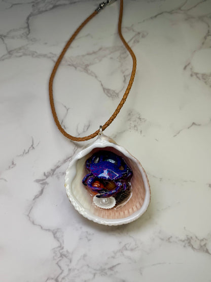 Moonlit Reef Wanderer Natural seashell featuring a handcrafted purple-and-blue spotted crab with tiny seashells encapsulated in clear UV resin Leather Corded necklace