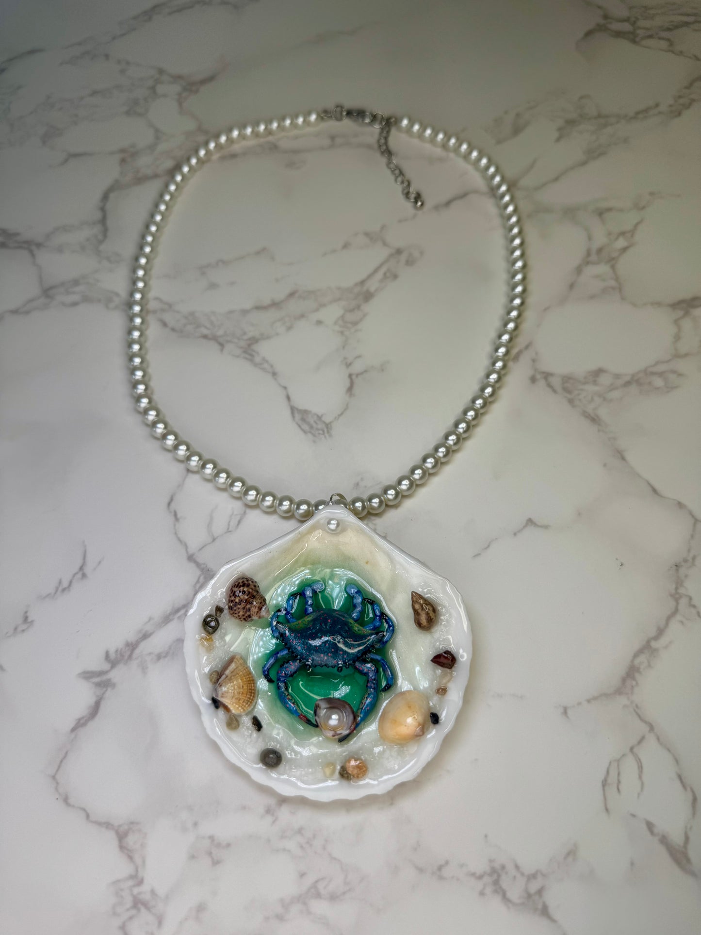 Tidal Blossom Crab Natural seashell featuring a handmade blue-and-pink dotted crab and small seashells encapsulated in clear UV resin Glasses Necklace