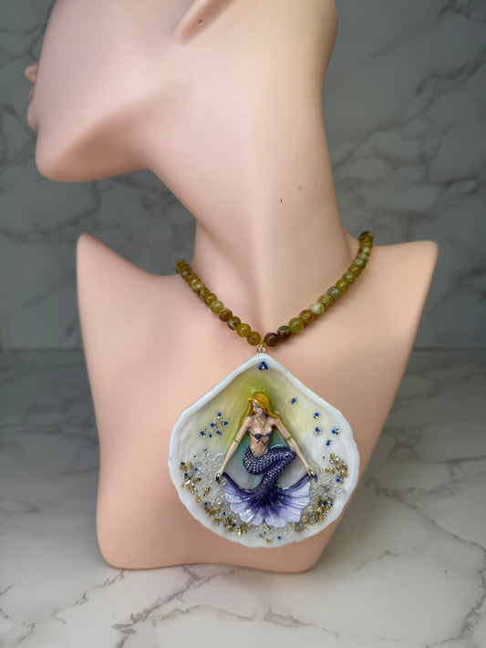 Bluewave Siren Natural seashell featuring a miniature mermaid with blonde hair and a shimmering blue tail encapsulated in clear UV resin