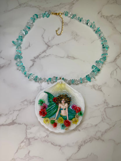 Blooming Tides Enchantress Natural seashell featuring a handmade craft metal mermaid with yellow hair and a shimmering green tail preserved in clear UV Resin. Natural Stones Necklace