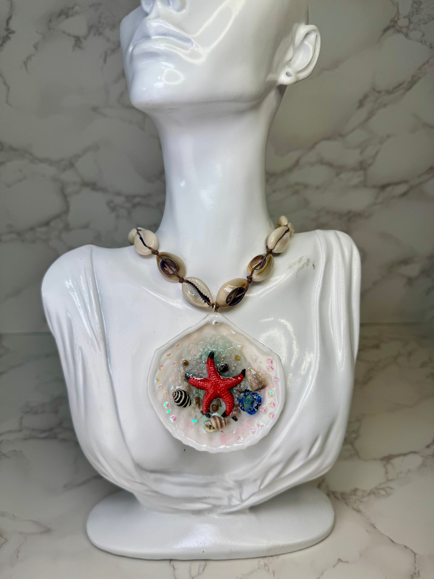 Tidebound Glow Natural seashell featuring a metal handmade craft red starfish, tiny black-and-white shells, and a swirled seashell necklace encapsulated in clear UV resin Natural shells necklace