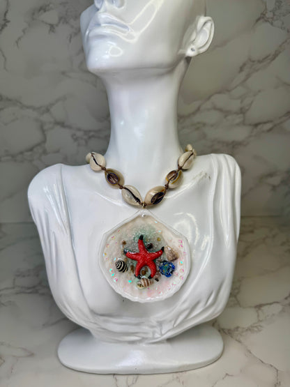 Tidebound Glow Natural seashell featuring a metal handmade craft red starfish, tiny black-and-white shells, and a swirled seashell necklace encapsulated in clear UV resin Natural shells necklace