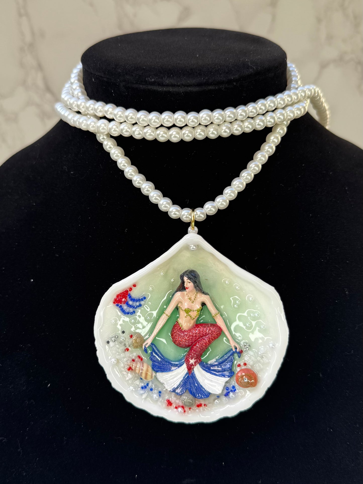 Cuba Libre Mermaid Natural seashell featuring a handmade craft metal mermaid with brown hair and a red tail inspired by the Cuban flag preserved in UV resin Beautiful Stones Necklace Handmade craft jewelry Crystal Pearl Necklace
