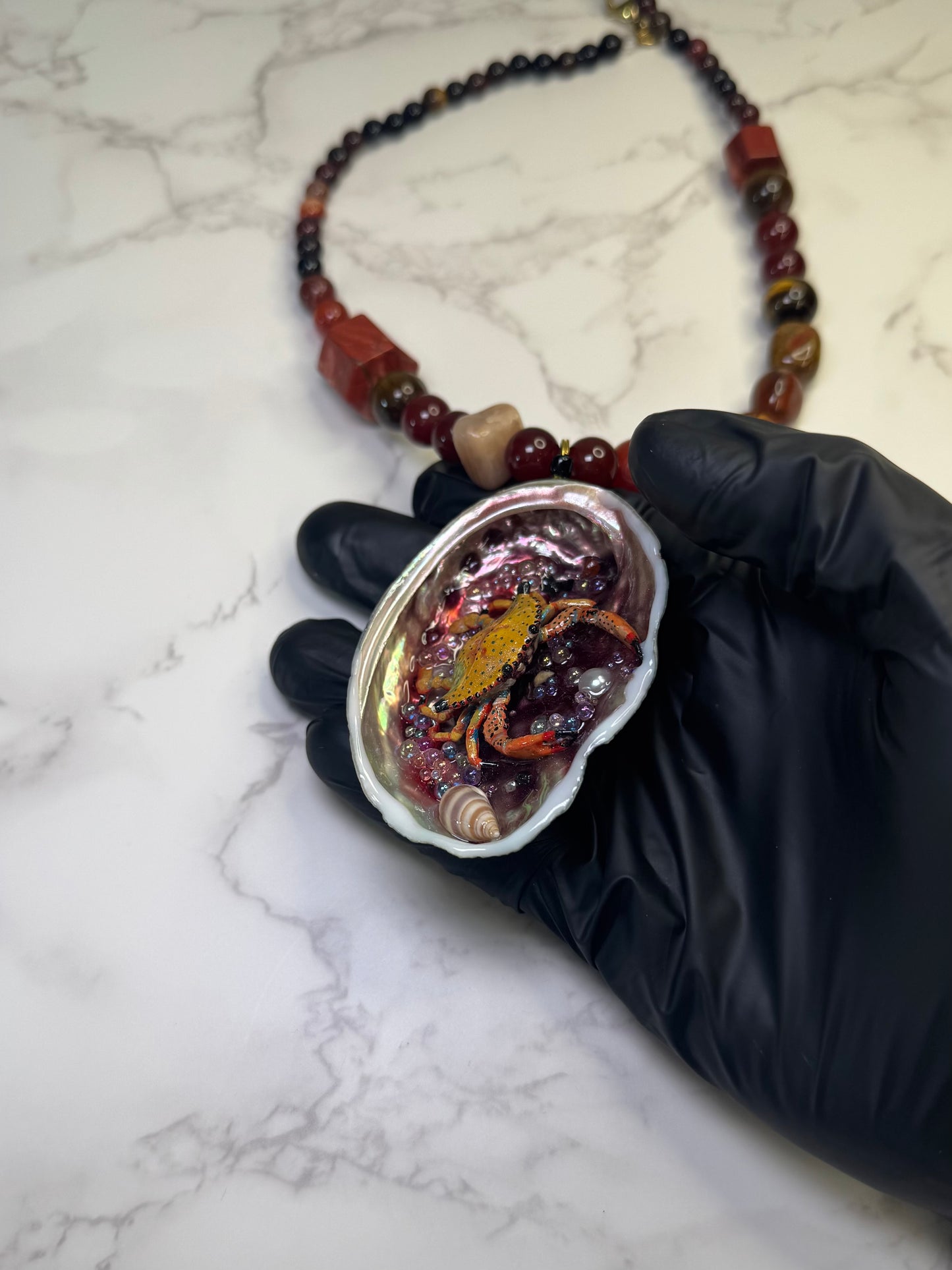 Amber Tide Spark Natural seashell featuring a miniature orange-and-black spotted crab and many tiny clear glass balls