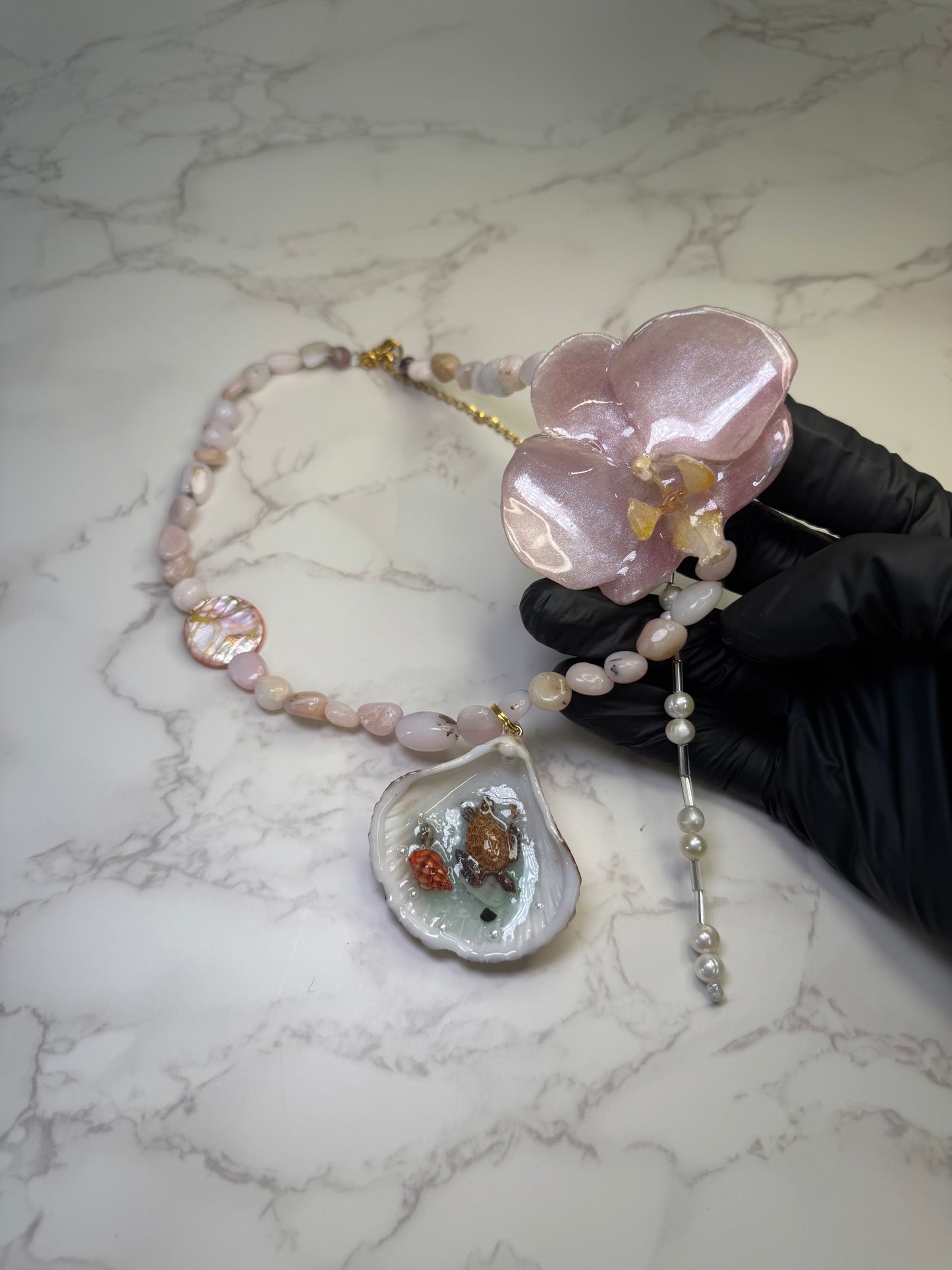 Pink Orchid Blossom Pink orchid flower centerpiece with a pink seashell holding a miniature sea turtle