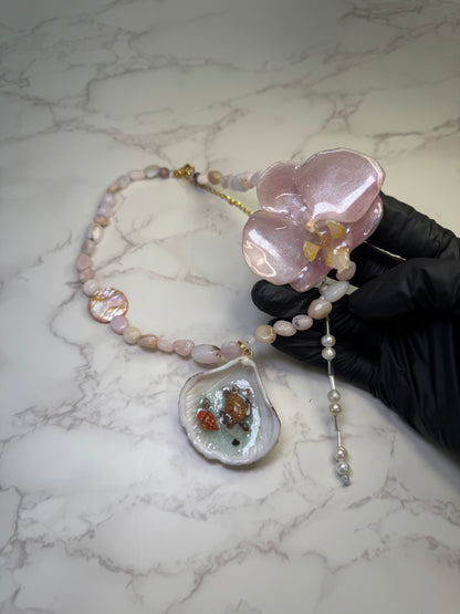 Pink Orchid Blossom Pink orchid flower centerpiece with a pink seashell holding a miniature sea turtle