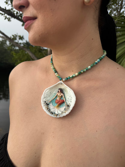 Sunlit Coral Siren Natural seashell featuring a handmade craft metal mermaid with brown hair, yellow highlights, and an orange–yellow tail encapsulated in clear UV resin Beautiful semiprecious stones necklace