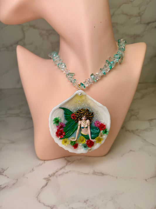 Blooming Tides Enchantress Natural seashell featuring a miniature mermaid with yellow hair and a shimmering green tail