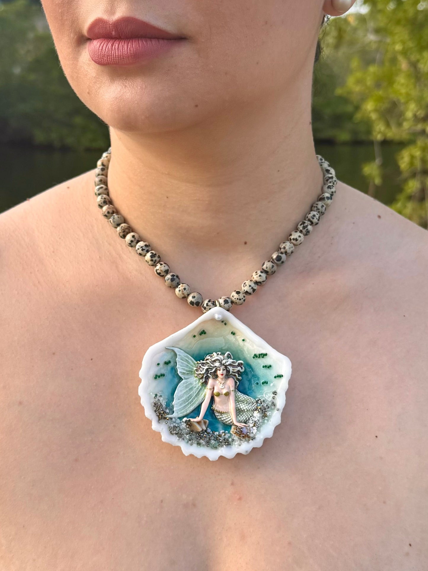 Moonshell Siren Natural seashell featuring a handmade craft metal mermaid with white hair and a pearlescent white tail encapsulated in clear UV resin Beautiful semiprecious stones necklace