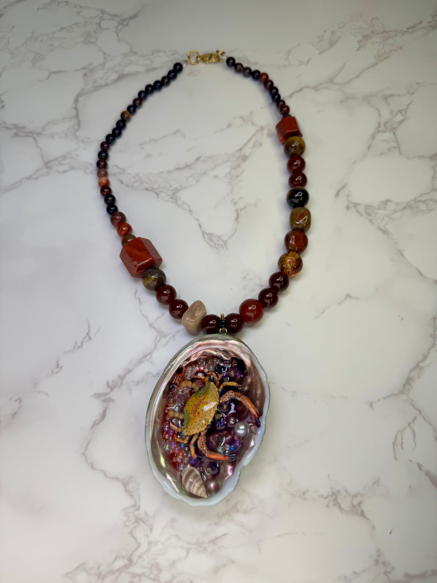 Amber Tide Spark Natural seashell featuring a miniature orange-and-black spotted crab and many tiny clear glass balls