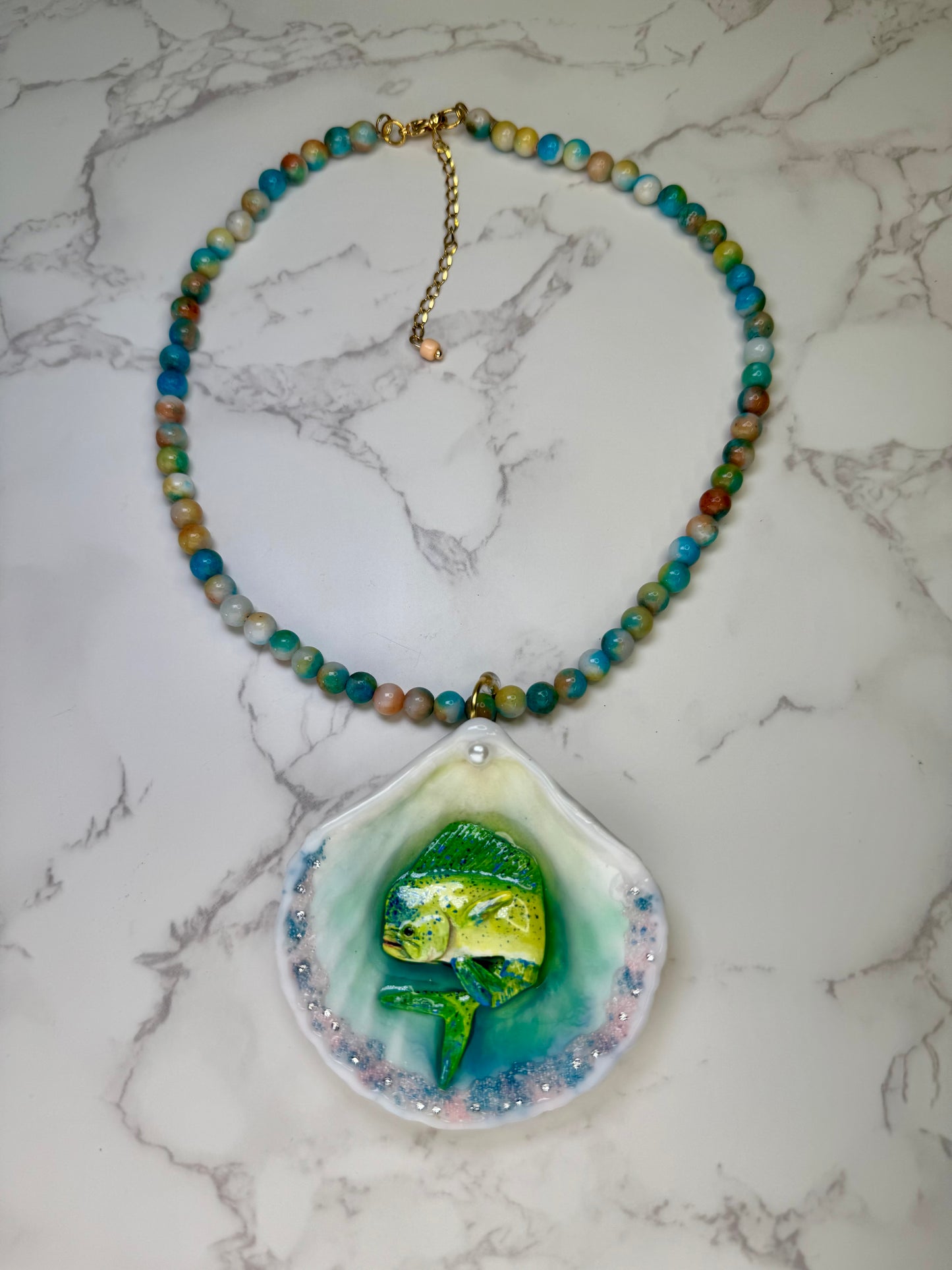 Tropical Horizon Drift Natural seashell featuring a beautiful unique metal handmade yellow-and-green mahi-mahi, glittered sand, and clear gems preserved in clear UV resin Beautiful natural stones necklace
