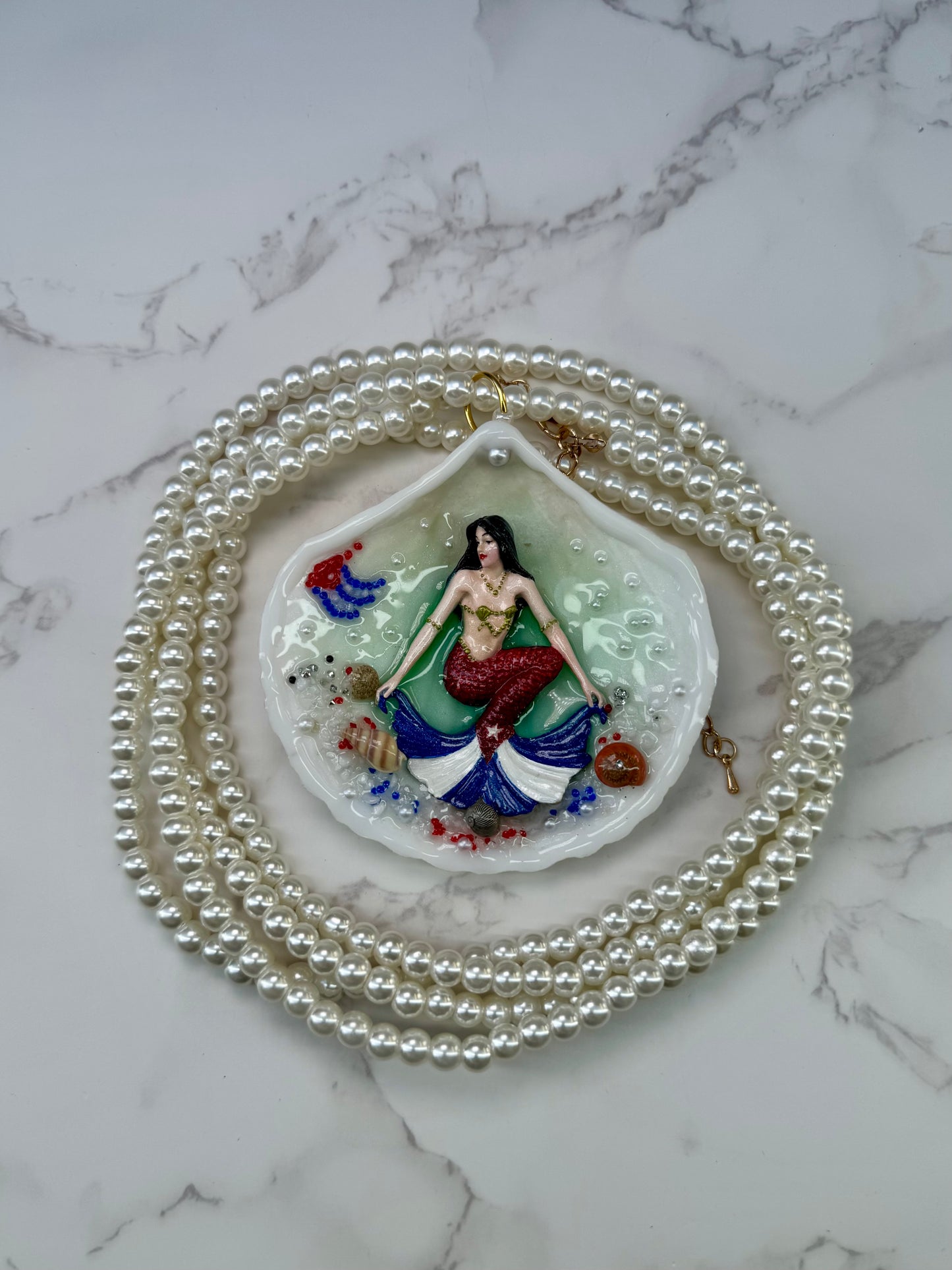 Cuba Libre Mermaid Natural seashell featuring a handmade craft metal mermaid with brown hair and a red tail inspired by the Cuban flag preserved in UV resin Beautiful Stones Necklace Handmade craft jewelry Crystal Pearl Necklace