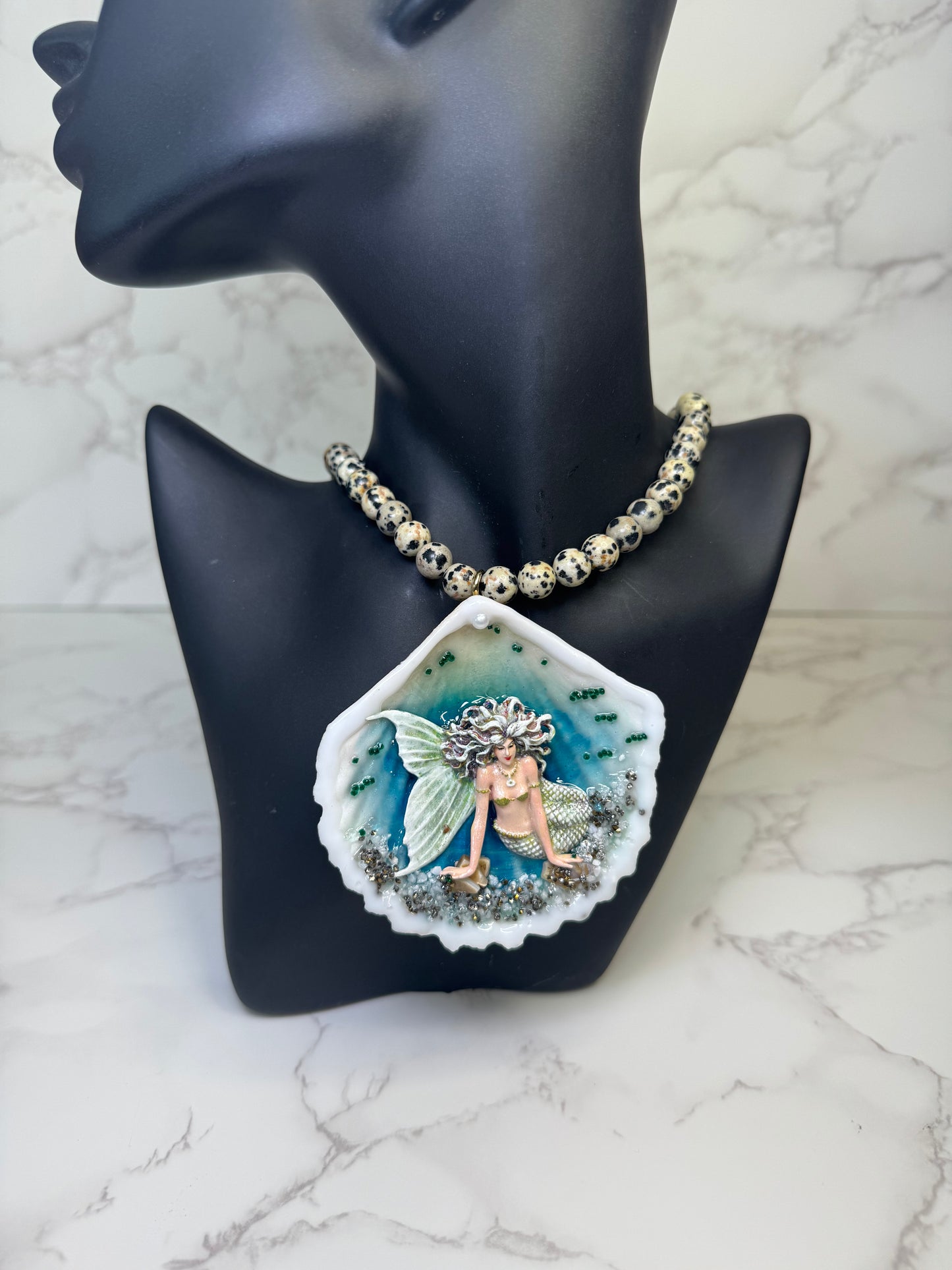 Moonshell Siren Natural seashell featuring a handmade craft metal mermaid with white hair and a pearlescent white tail encapsulated in clear UV resin Beautiful semiprecious stones necklace