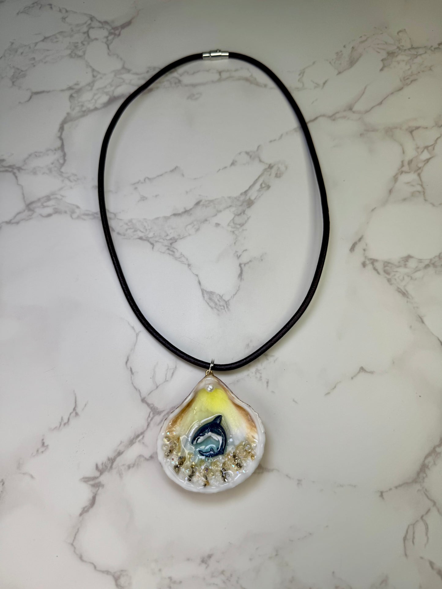 Mini Tide Hunter Tiny natural seashell featuring a handmade craft metal miniature shark and small crystals encapsulated in clear UV resin.  Leather necklace