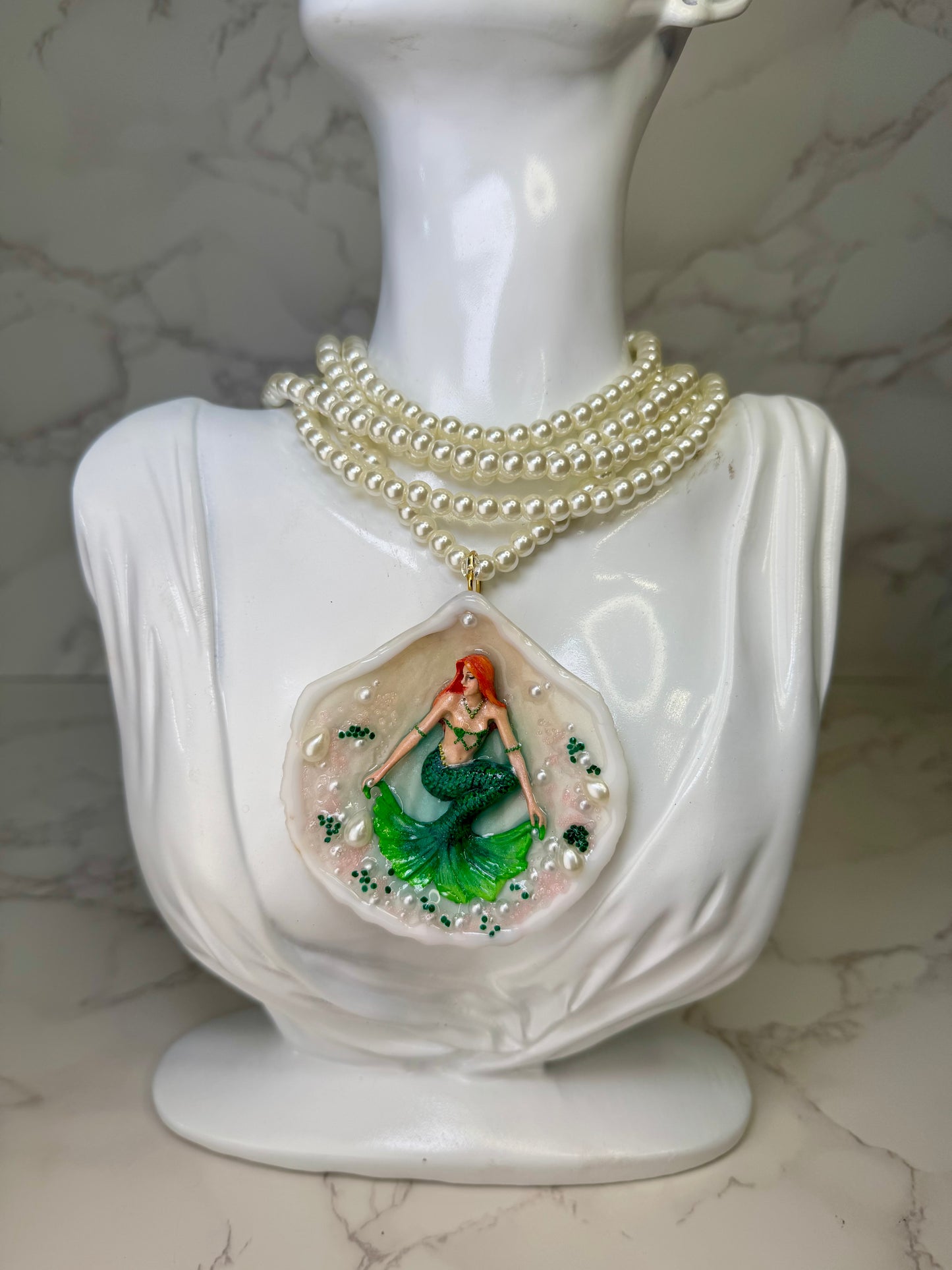 Emerald Siren Whisper Natural seashell featuring a handmade craft metal mermaid with orange hair and a shimmering green tail encapsulated in clear UV resin Beautiful extra long Glasses Pearls Necklace