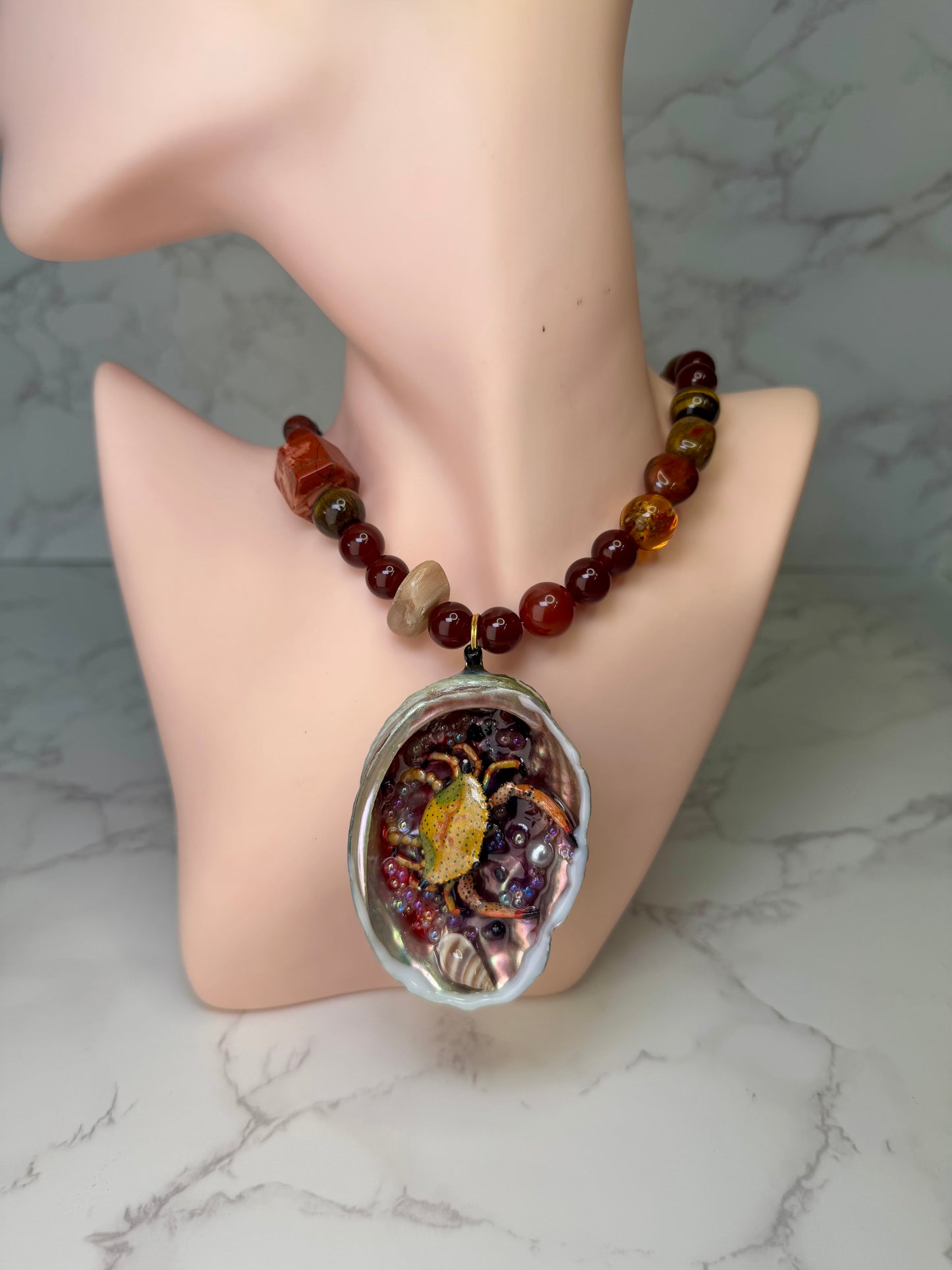 Amber Tide Spark Natural seashell featuring a miniature orange-and-black spotted crab and many tiny clear glass balls