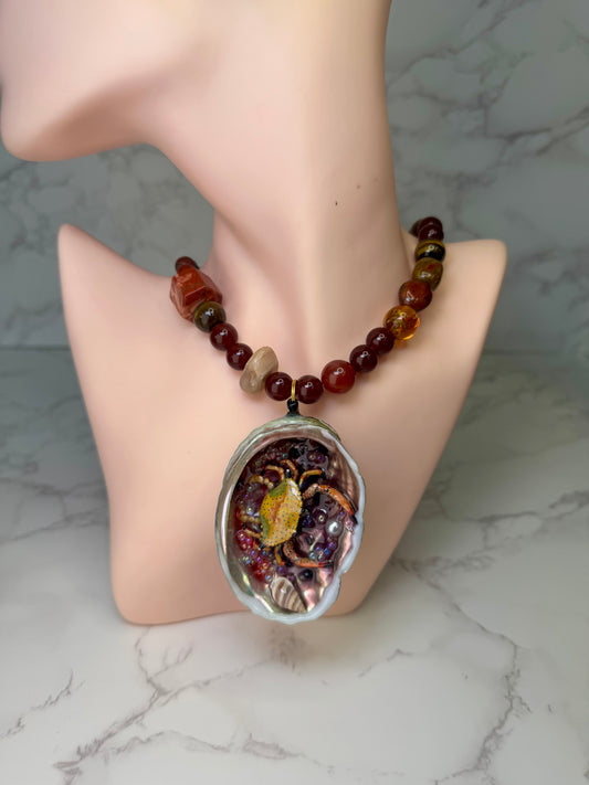 Amber Tide Spark Natural seashell featuring a miniature orange-and-black spotted crab and many tiny clear glass balls