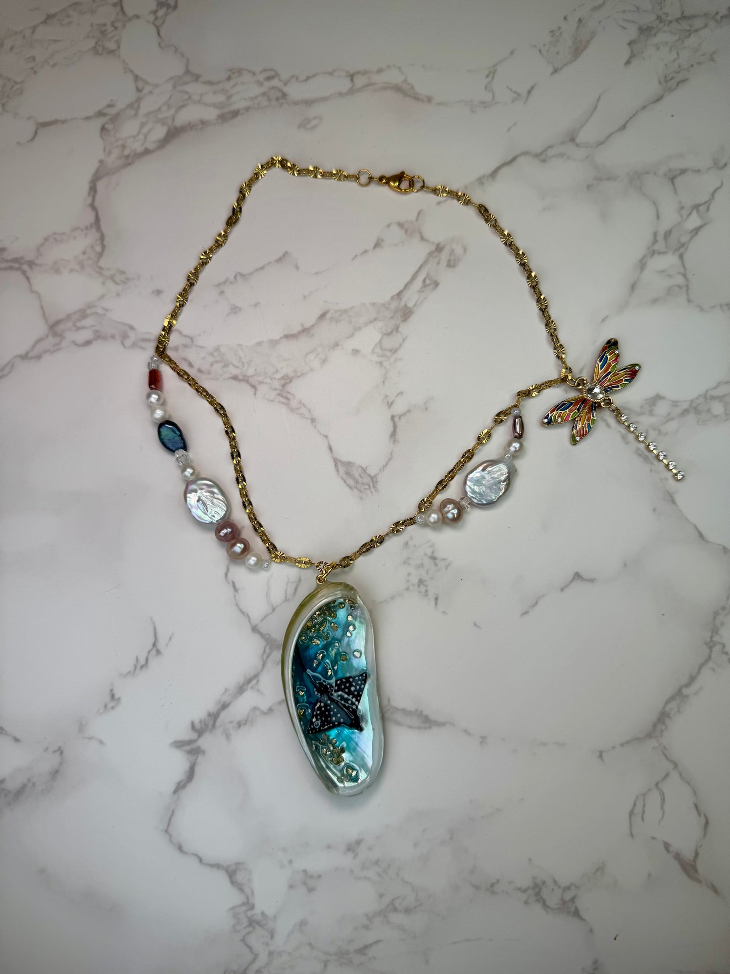 Starlit Reef Natural seashell featuring a miniature black-spotted manta ray and a gemmed dragonfly trinket encapsulated in clear UV resin